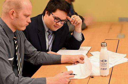 Two MBA students analyzing a table.