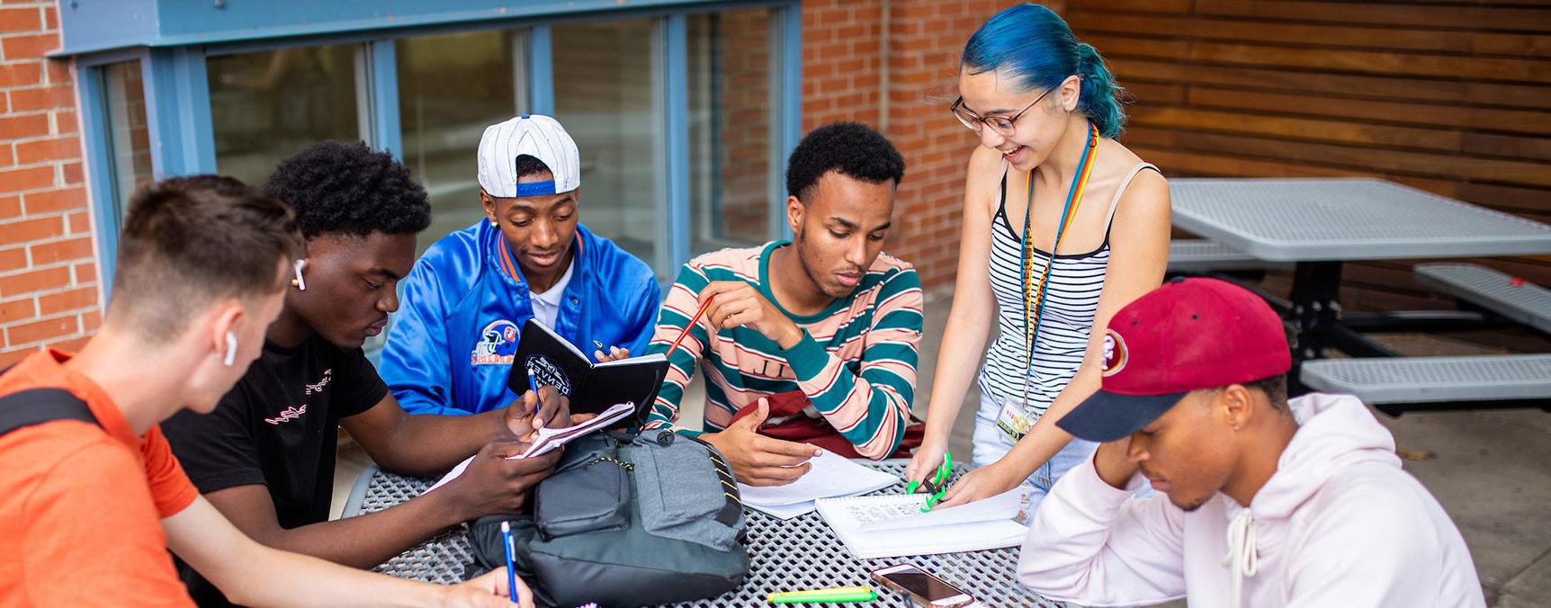 College credit in high school students sitting around at table studying