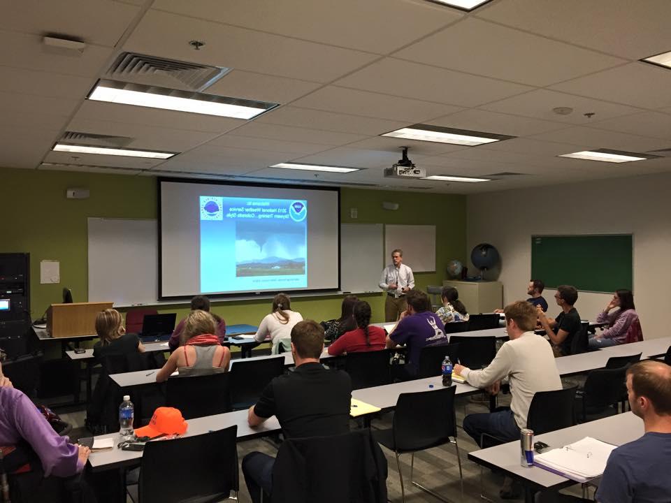 Students in a classroom watching the NWS lead train them on storm spotting