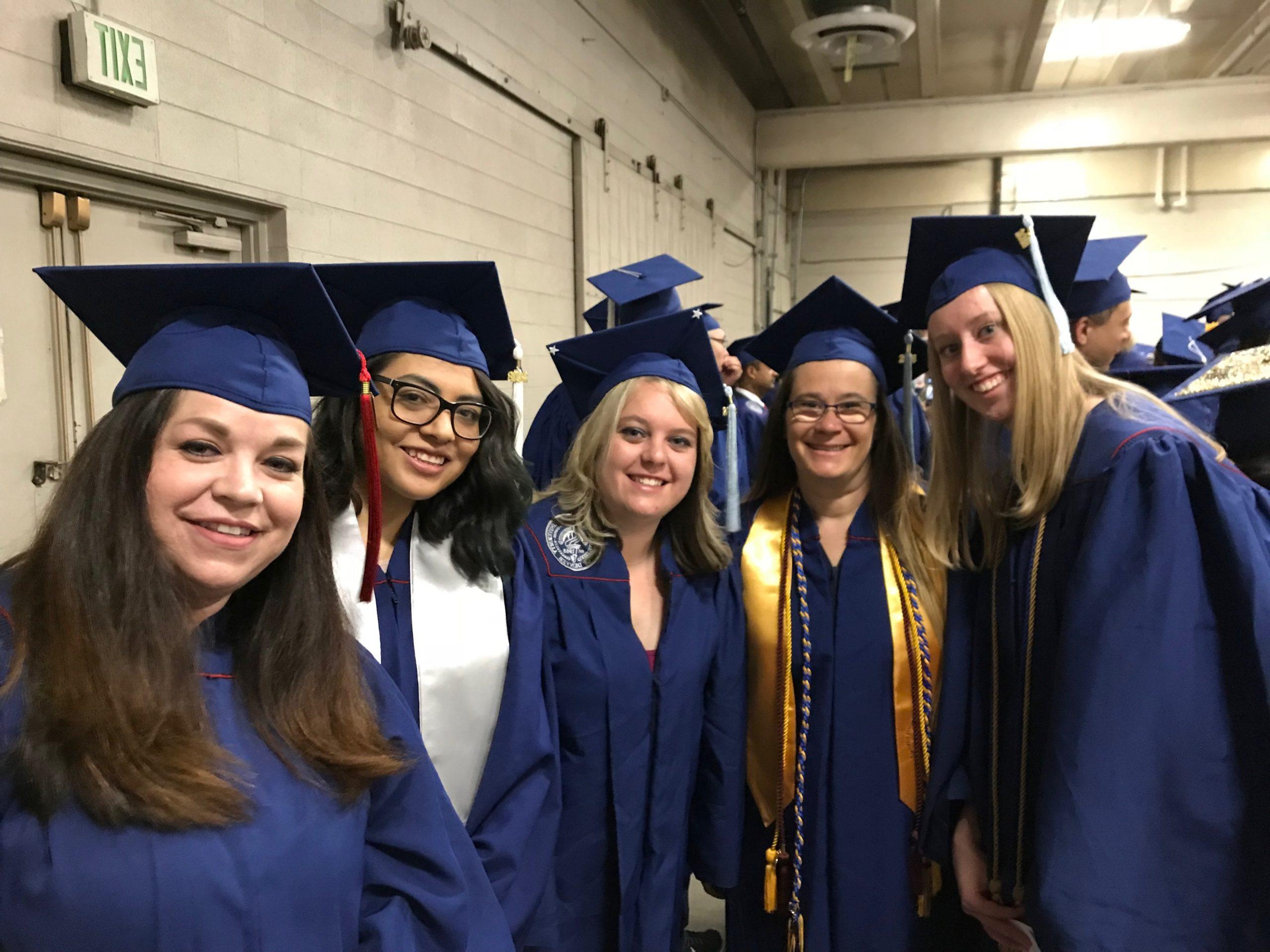 Graduating math & statistics students posing for a photo with a professor