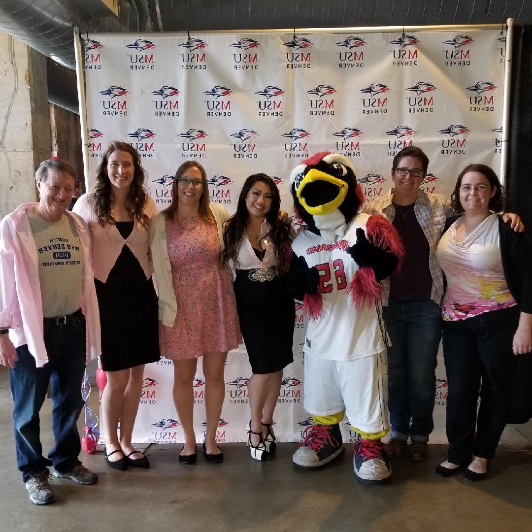 Math and Stats faculty posing with Rowdy in front of an MSU Denver themed backdrop