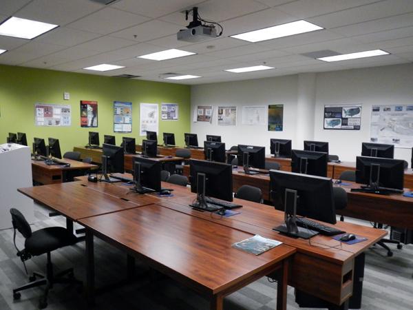 GIS computer lab with brown wood top desks and 24 computers