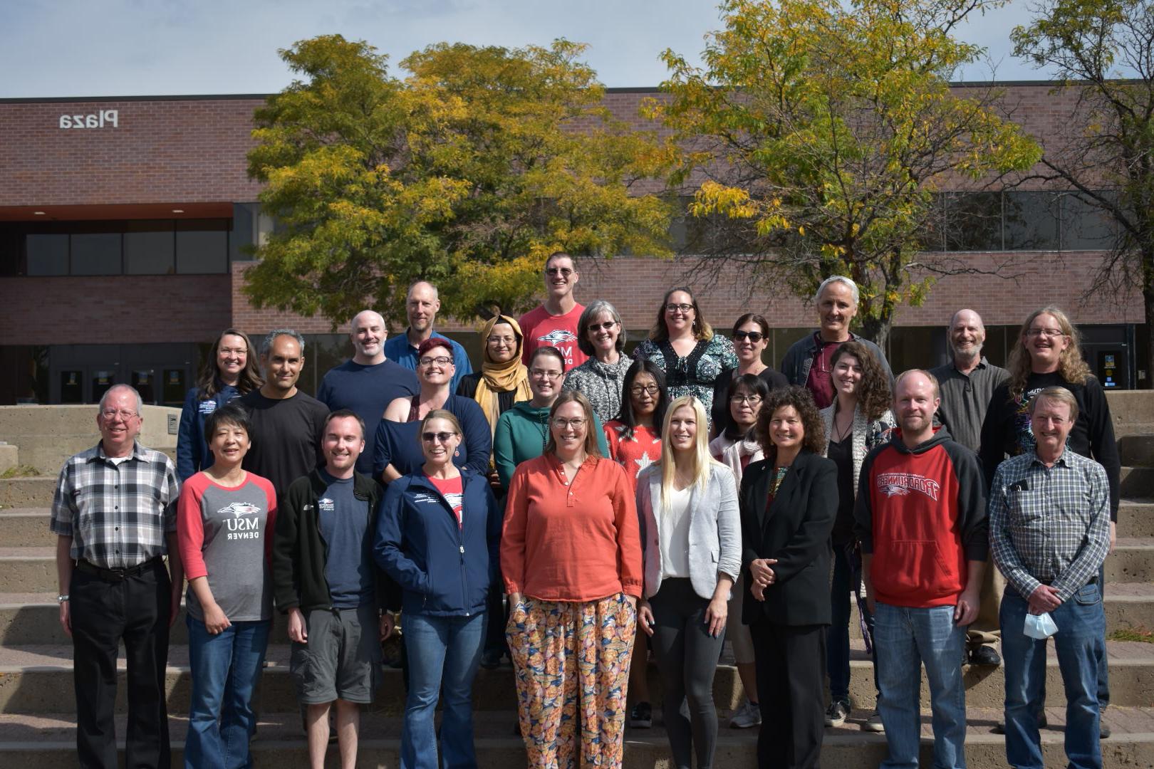 Department of Math and Statistics faculty smiling in front of the Plaza Building