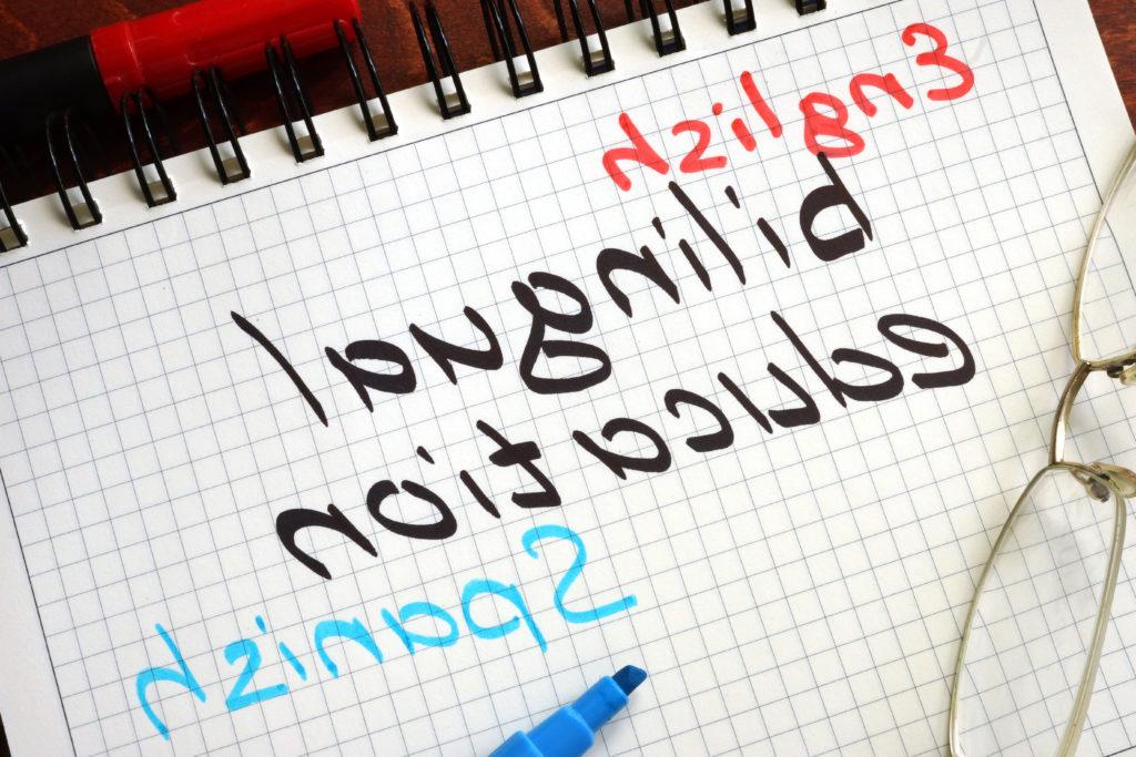 Photo of a piece of grid paper in a notebook with "English, Bilingual Education, Spanish" written in red, black and blue marker.