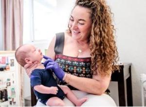 Photo of woman holding a newborn baby.