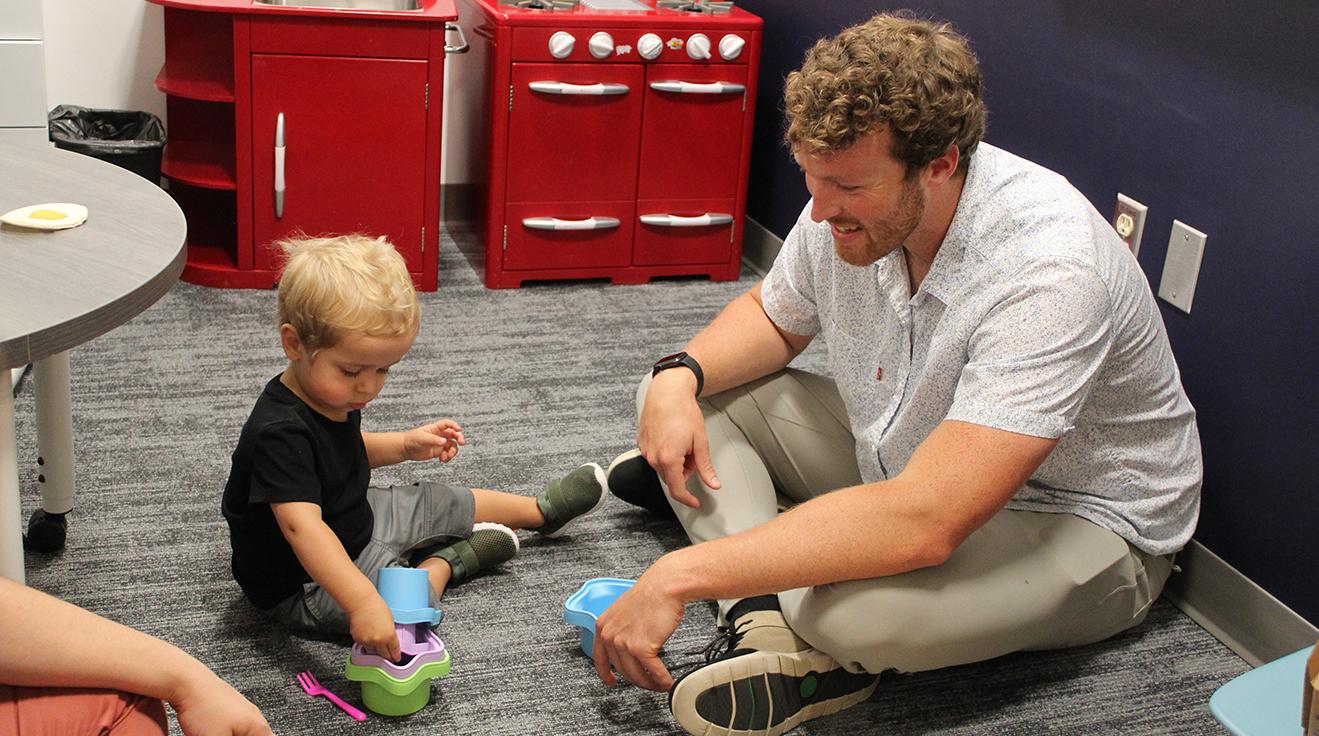 Graduate MS SLP student (left) working with toddler aged child (right)