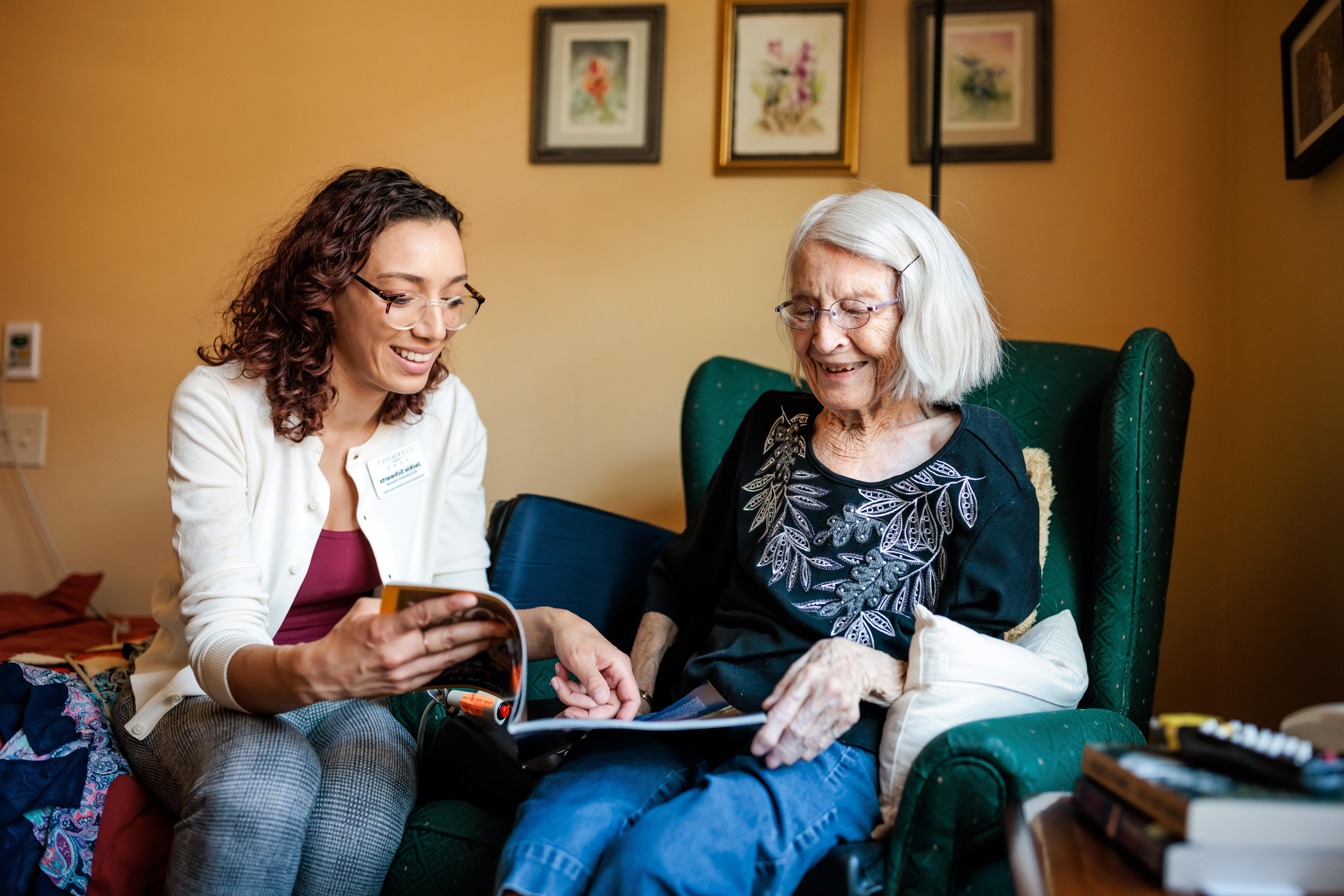 MSU Denver student Jackie Schwartz reads about Egyptology and mummification with resident Jeanne Dietrich in her room at Clermont Park- senior community living on May 17, 2023. Photo by Alyson McClaran