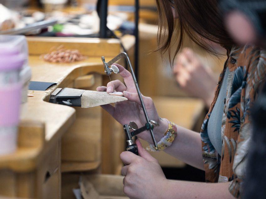 A student uses a saw.