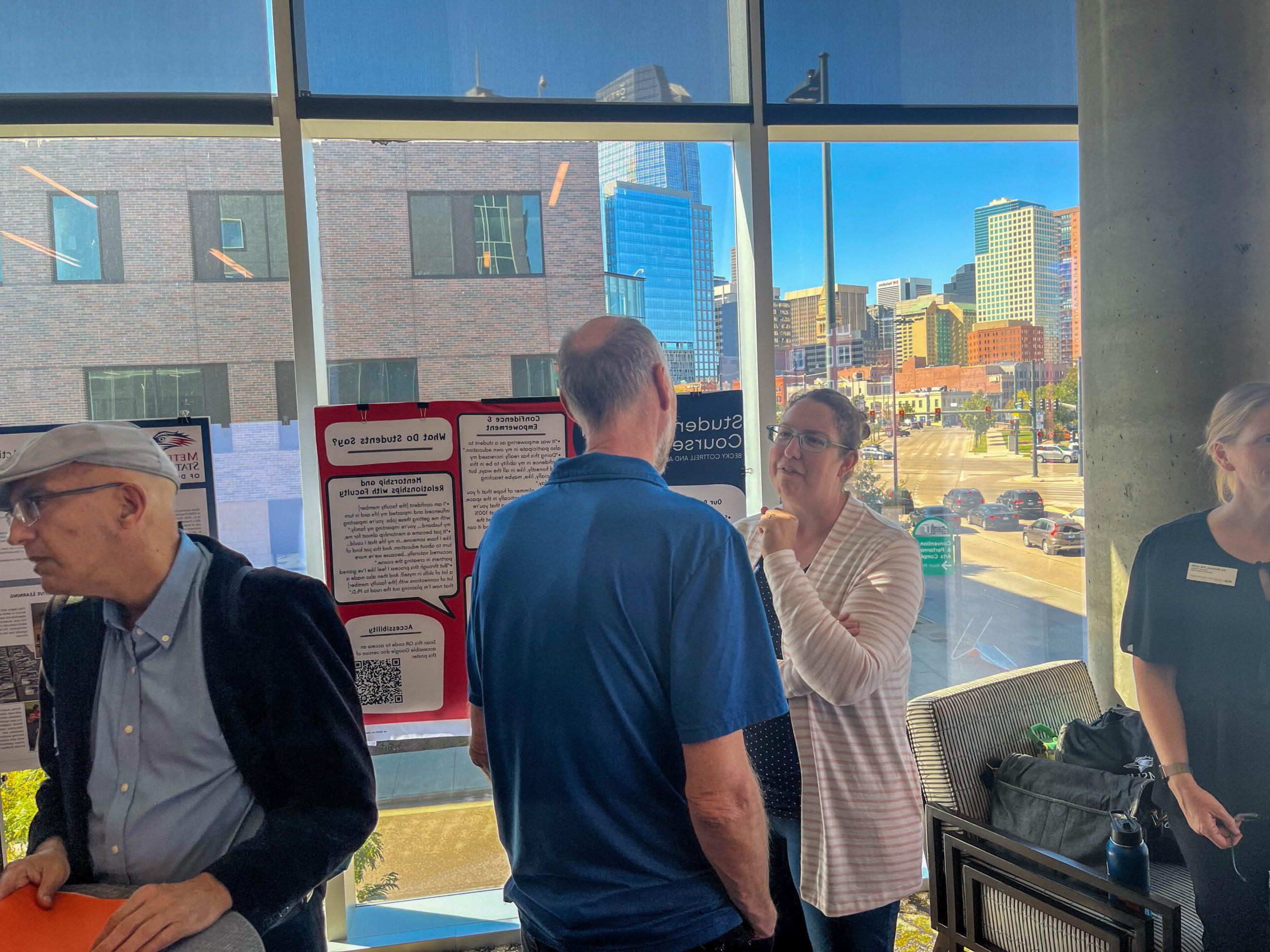 Faculty and staff discussing research projects at the SoTL poster session