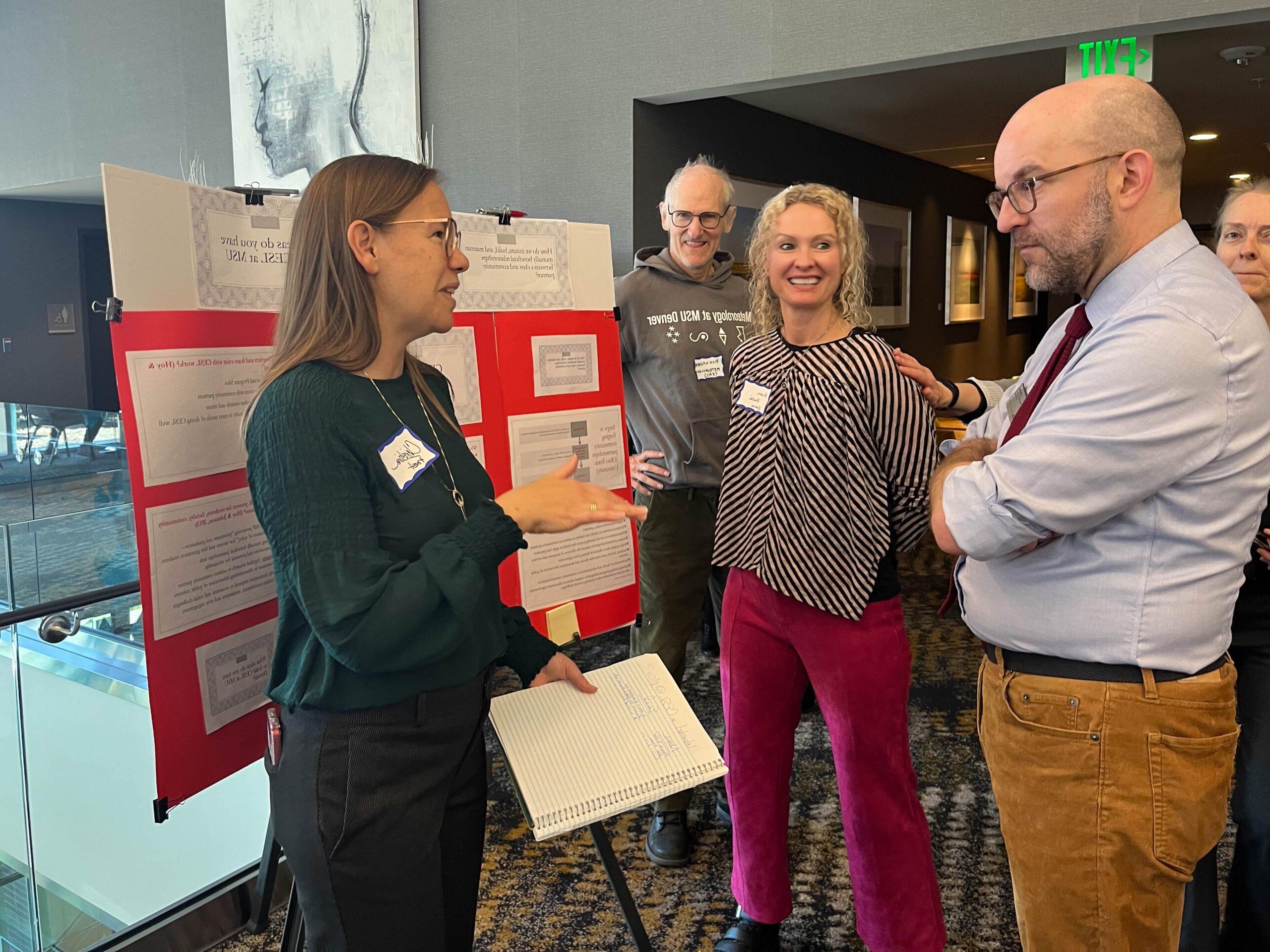 Faculty and staff discussing research projects at the SoTL poster session