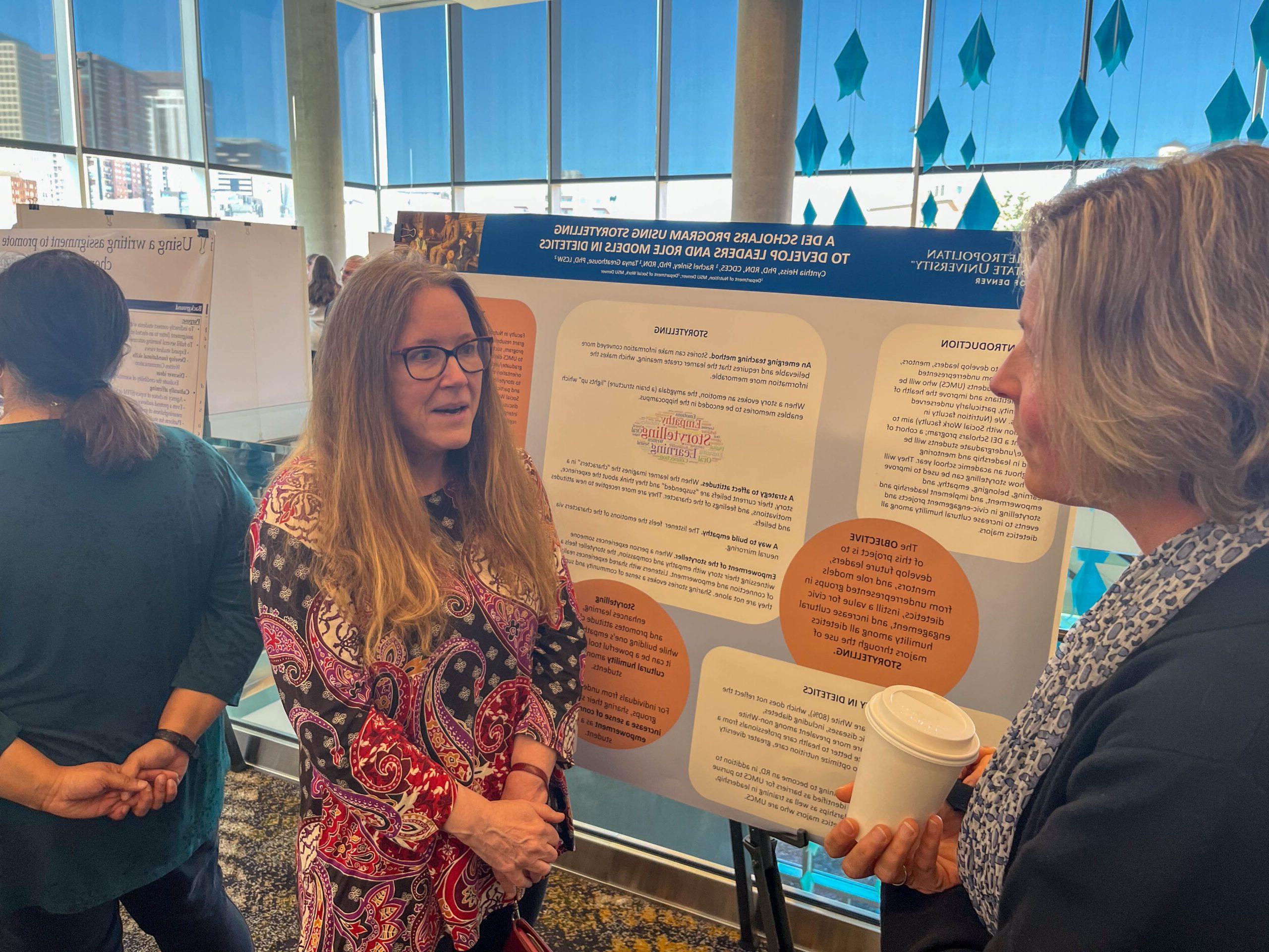 Faculty and staff discussing research projects at the SoTL poster session