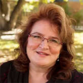 A picture of Dawn Materra Bassett with a leafy Auraria campus in the background