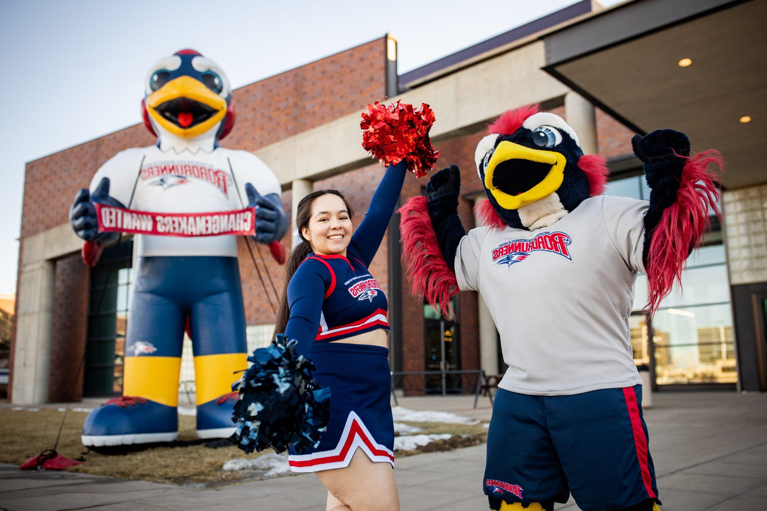 A 密歇根州立大学丹佛 cheerleader and Rowdy pose in front of a big blow-up Rowdy