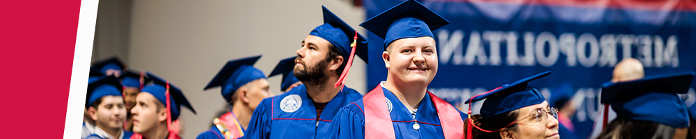 A group of MSU Denver graduates in cap and gown smiling at Commencement.